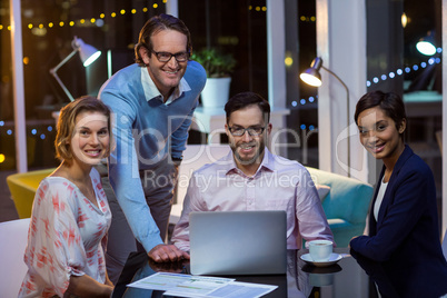 Businesspeople having discussion over laptop