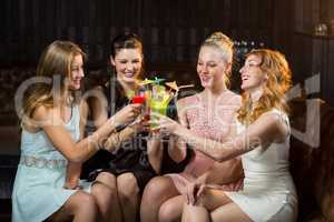 Female friends toasting glasses of cocktail in bar