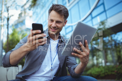 Business executive using mobile phone and digital tablet