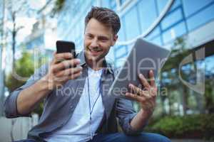 Business executive using mobile phone and digital tablet