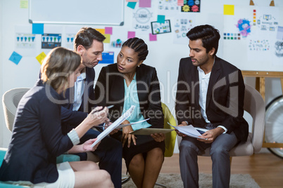 Group of businesspeople discussing in front of whiteboard