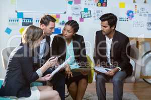 Group of businesspeople discussing in front of whiteboard