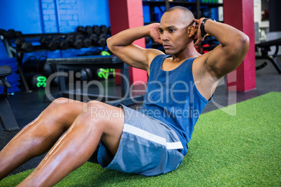 Young male athlete with hands behind back in gym