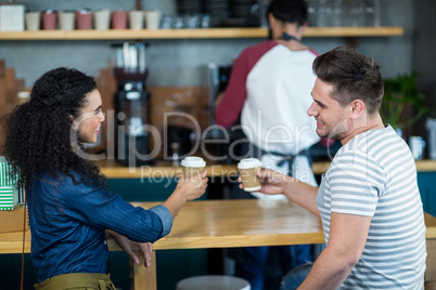 Smiling young couple having coffee in cafe