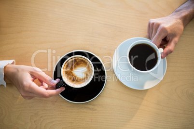 Hands of couple holding cup of coffee