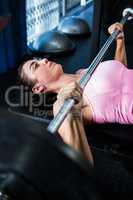 Female athlete holding barbell in gym