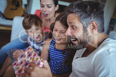 Family opening the surprise gift  in living room