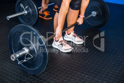 People lifting barbell at gym