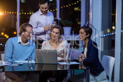 Businesspeople having discussion over laptop