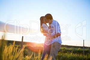 Affectionate couple kissing in field