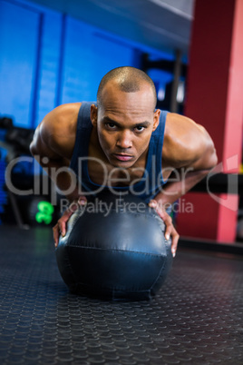 Young man using exercise ball in gym