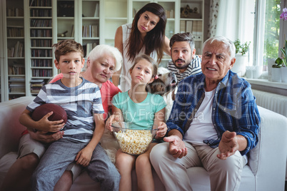 Unhappy multi-generation family watching soccer match on television in living room