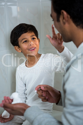 Son applying foam on fathers face