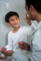 Son applying foam on fathers face