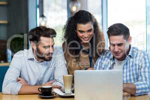 Friends using laptop in cafÃ?Â©