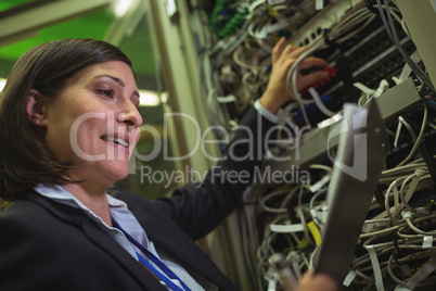 Technician maintaining record of rack mounted server on clipboard