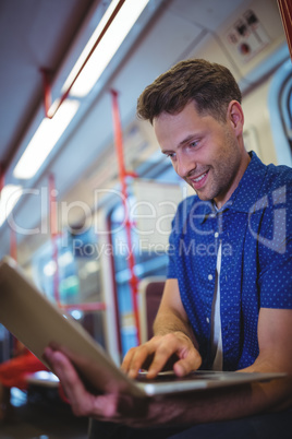 Handsome man using laptop in train