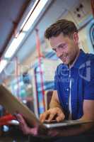Handsome man using laptop in train