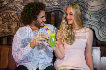 Couple toasting glass of cocktail in bar