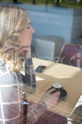 Woman having coffee in cafeteria