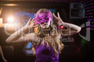 Woman with masquerade dancing on dance floor