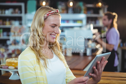 Smiling woman using digital tablet