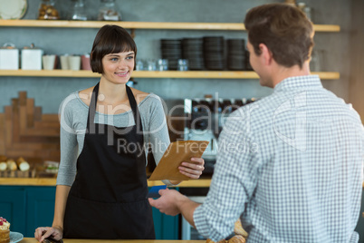 Waitress giving parcel to customer at counter