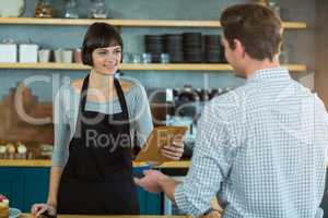 Waitress giving parcel to customer at counter
