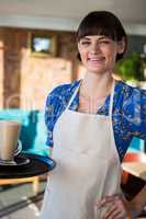 Smiling waitress holding a glass of coffee