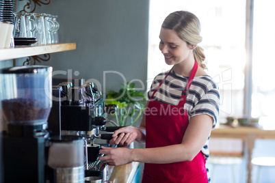 Waitress making cup of coffee in cafÃ?Â©