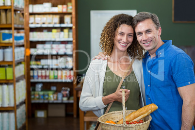 Portrait of happy couple standing with a basket