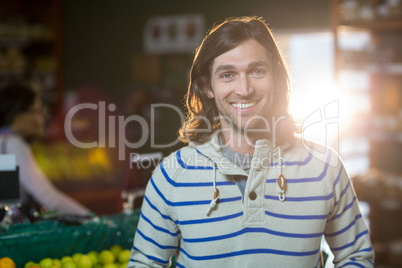 Smiling man standing in organic section