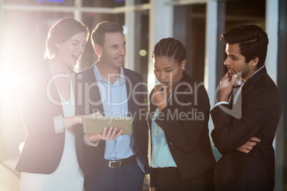 Group of businesspeople discussing together over digital tablet Group of businesspeople discussing together over digital tablet