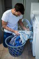 Man putting clothes into washing machine