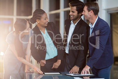 Group of businesspeople discussing together over digital tablet