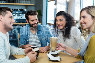 Smiling friends having a cup of coffee and cold coffee in cafÃ?Â©