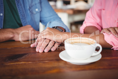 Mid-section of couple holding hands