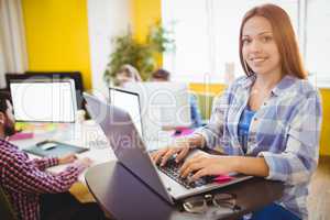 Happy businesswoman working with laptop
