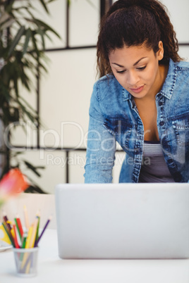 Businesswoman using laptop at desk