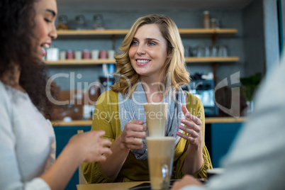 Smiling friends having a cup of cold coffee in cafÃ?Â©