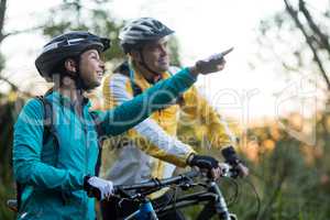 Biker couple with mountain bike pointing in distance