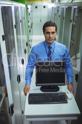 Technician walking with personal computer in hallway