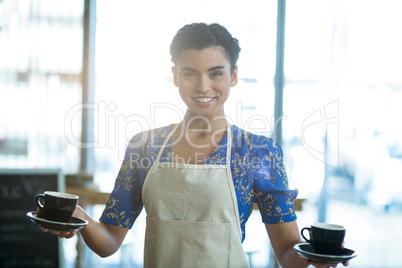 Portrait of waitress holding cup of coffee