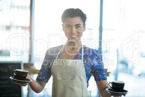 Portrait of waitress holding cup of coffee