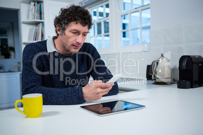 Man using mobile phone in the kitchen