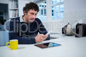 Man using mobile phone in the kitchen