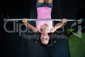 High angle view of athlete holding barbell while lying on bench press