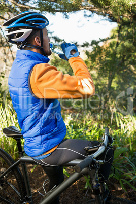 Male mountain biker drinking water