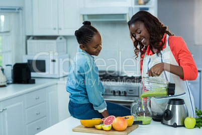 Daughter looking at mother pouring juice in a jug