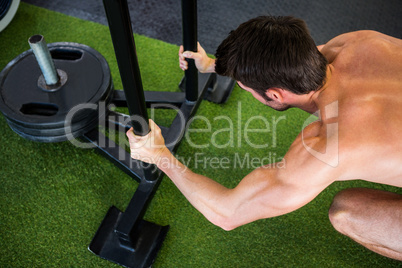Man holding poles while exercising in gym